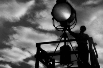 MANK film still of a man holding a spotlight