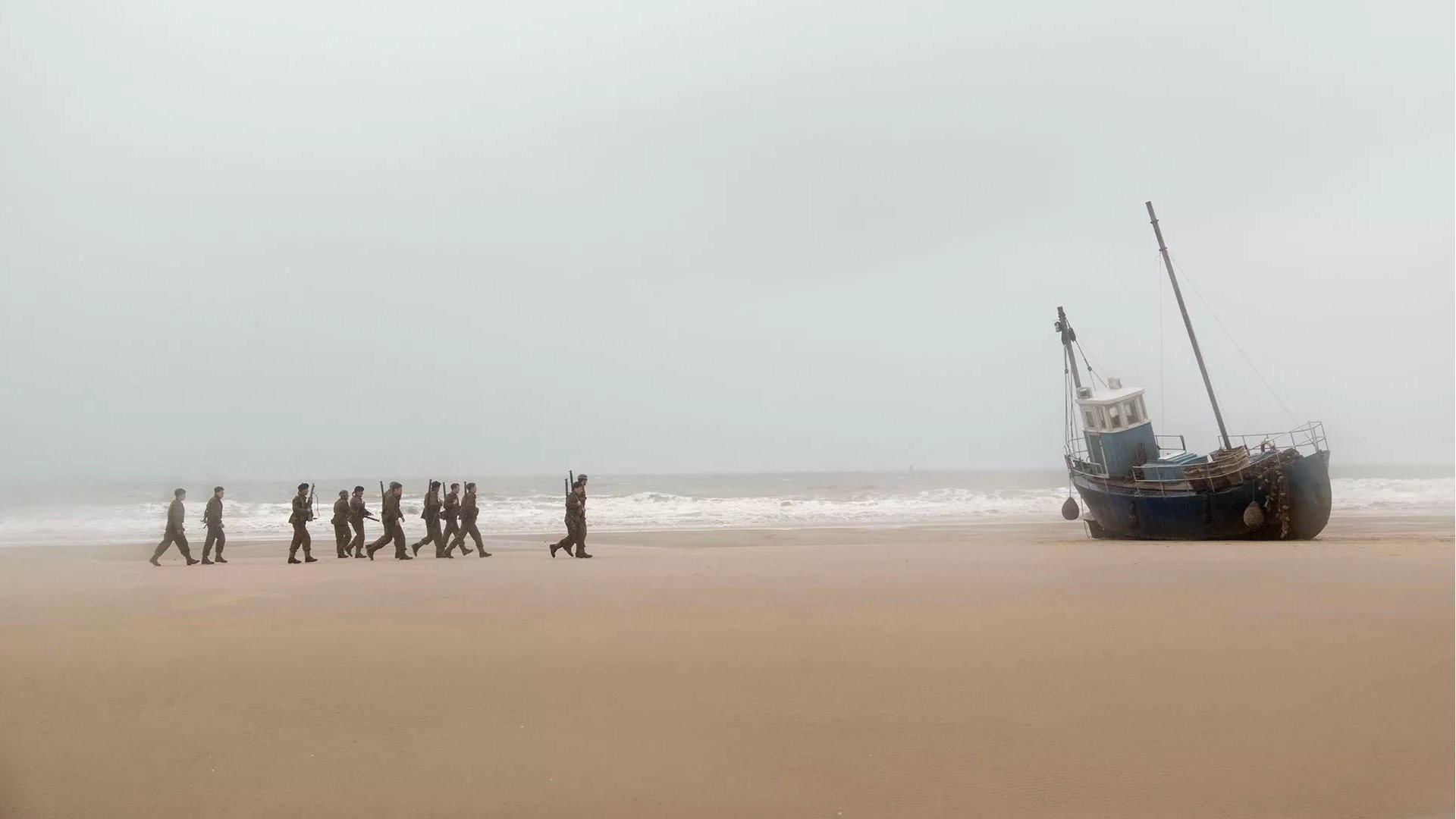 DUNKIRK film still of soldiers on a beach