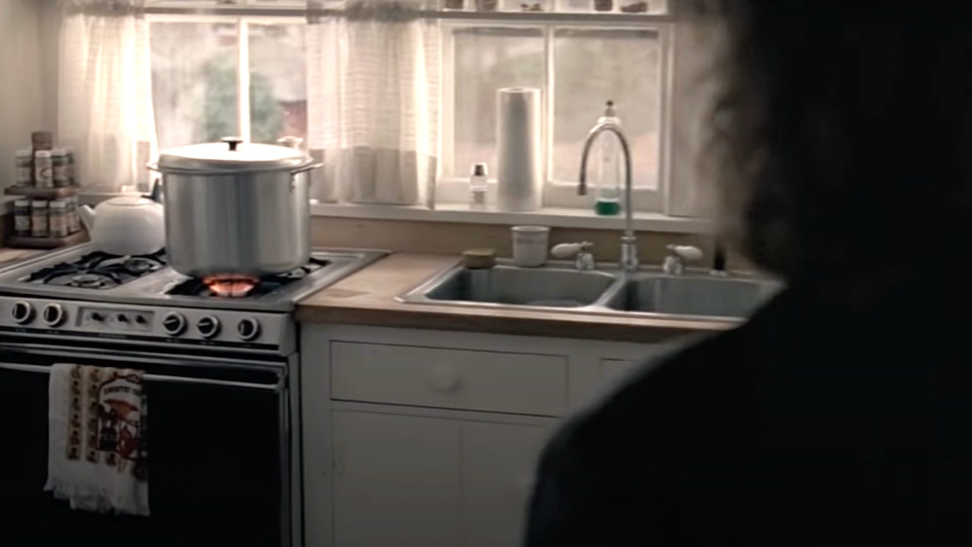 FATAL ATTRACTION film still of a woman facing a kitchen stove and sink