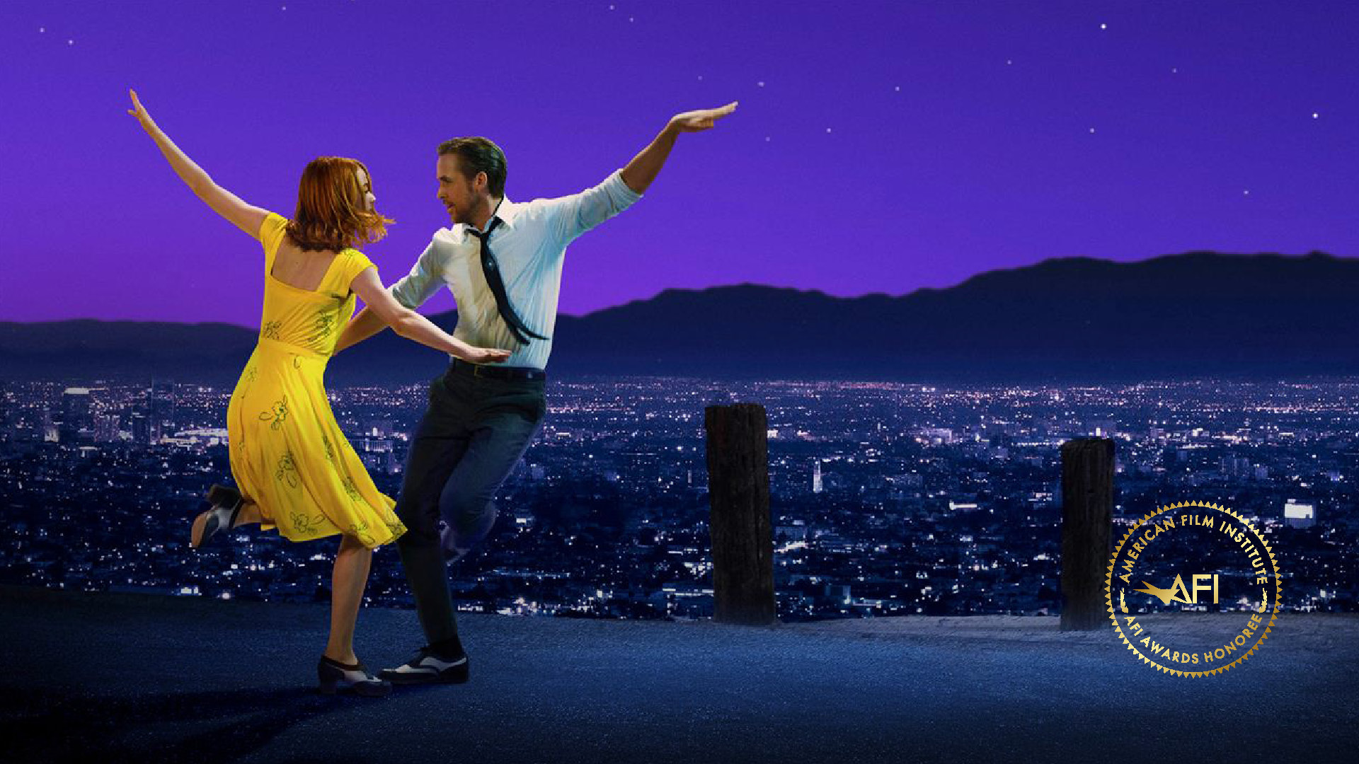 In the corner is the AFI AWARDS logo. The film still is from LA LA LAND and shows Mia and Sebastian (played by Emma Stone and Ryan Gosling) dancing with a purple sky and the lights of Los Angeles in the background.
