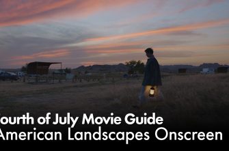 A blog post image featuring the title of the Fourth of July Movie Guide. The title is placed over a film still from NOMADLAND: Fern (Frances McDormand) is walking across an open field holding a lantern. The clouds, set against a blue-ish gray sky, are a tinged dark orange from the setting sun.