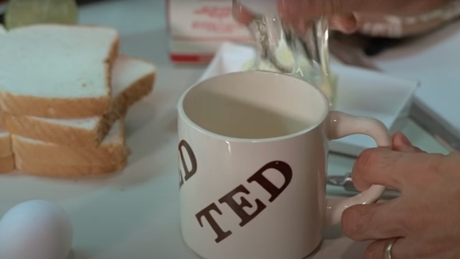 KRAMER VS. KRAMER film still of a white mug, an egg, and a stack of bread on a table