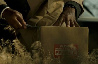 SE7EN film still of a man cutting open a cardboard box
