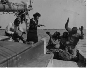 REGENERATION 1923 film still of characters on a boat. A woman points a pistol at several passengers who have their hands up.